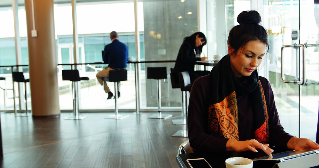 Woman Working on Tablet in Modern Cafe - Free Images, Stock Photos and Pictures on Pikwizard.com