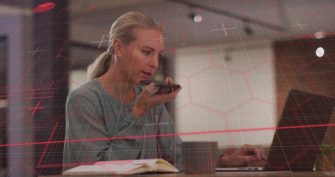 Business Professional Speaking into Smartphone and Using Laptop