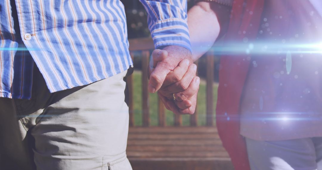Senior Couple Holding Hands in Park Glowing with Light