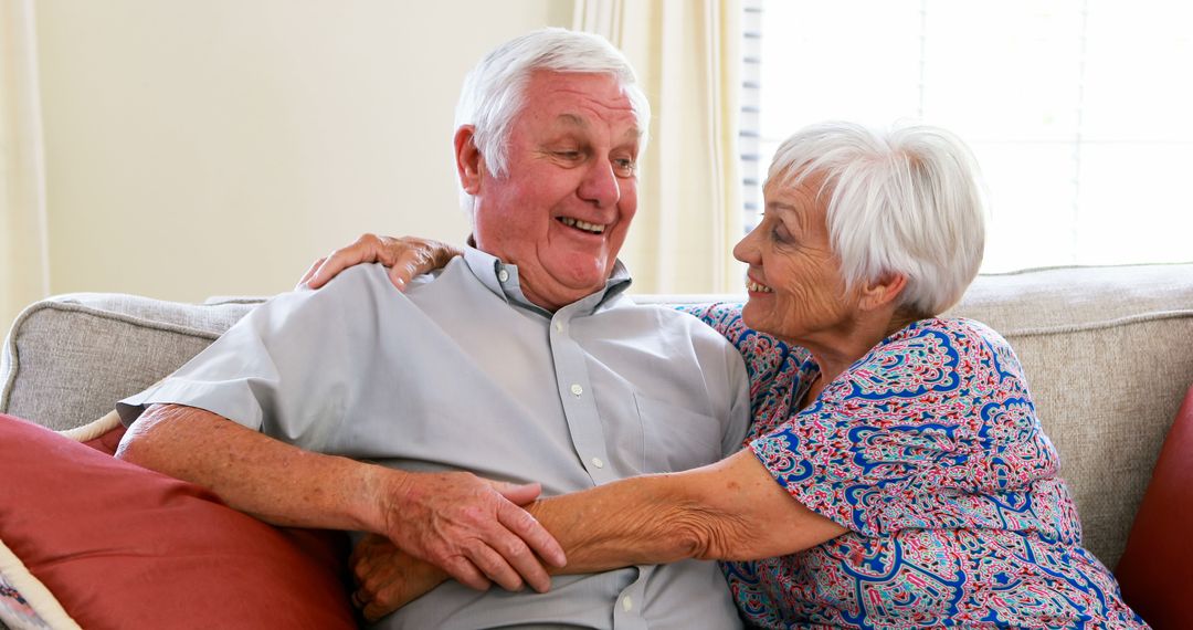 Happy Elderly Couple Relaxing on Couch at Home