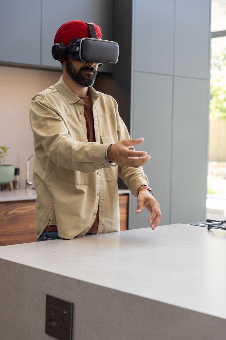 Man with VR Headset Manipulating Virtual Interface in Modern Kitchen