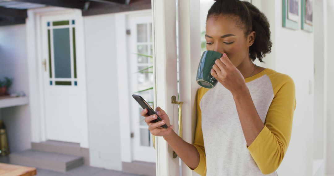 Young Woman Drinking Coffee while Using Smartphone at Home - Free Images, Stock Photos and Pictures on Pikwizard.com