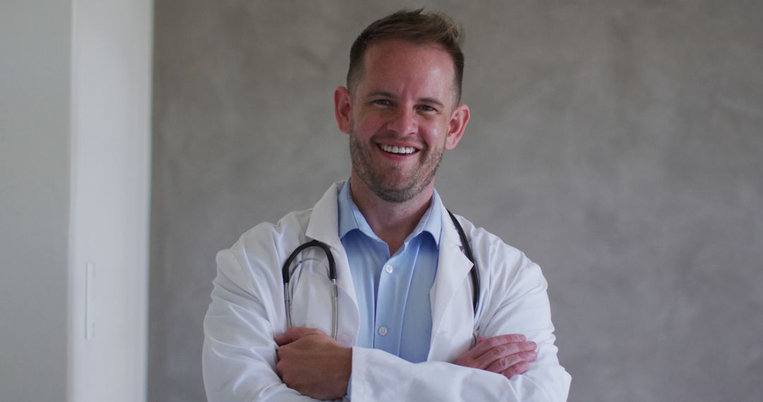 Smiling Doctor in White Coat Standing with Arms Crossed - Free Images, Stock Photos and Pictures on Pikwizard.com