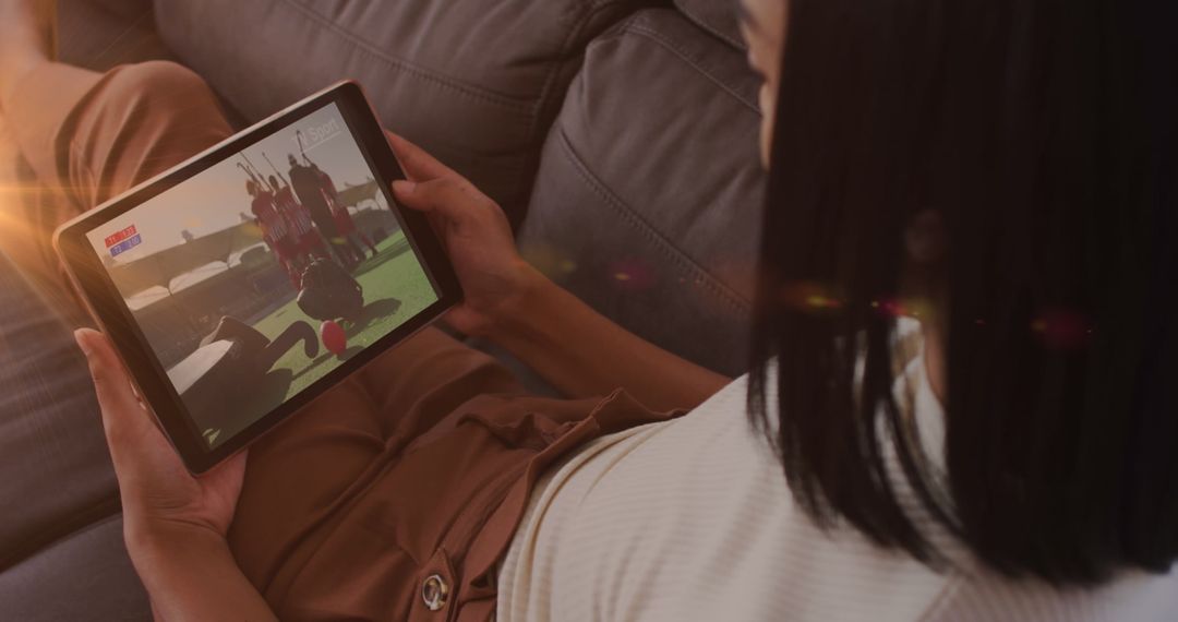Woman Relaxing on Couch Watching Football on Tablet