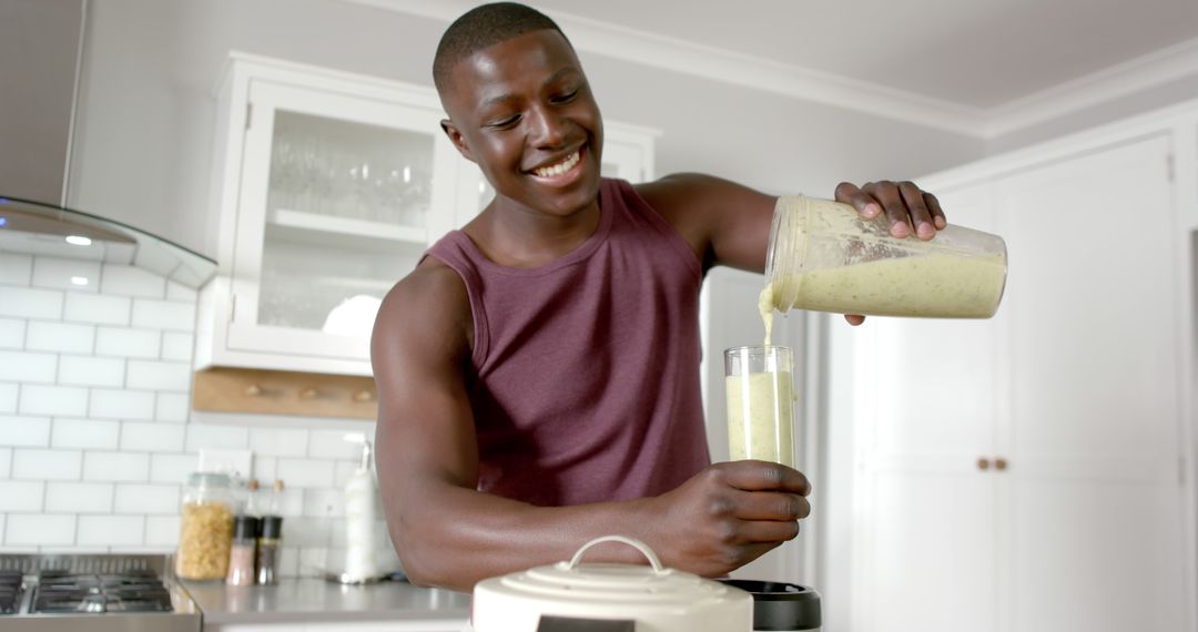 Smiling Young Man Making Healthy Green Smoothie in Modern Kitchen - Free Images, Stock Photos and Pictures on Pikwizard.com