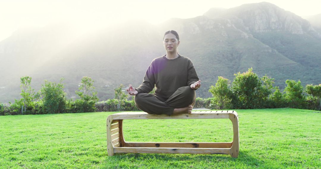 Woman Meditating on Bench with Mountain View in Tranquil Setting