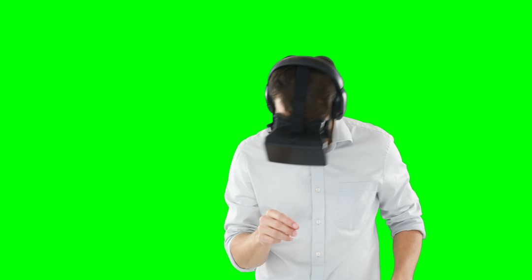 Man Wearing VR Headset Immersed in Digital Experience on Green Screen - Free Images, Stock Photos and Pictures on Pikwizard.com