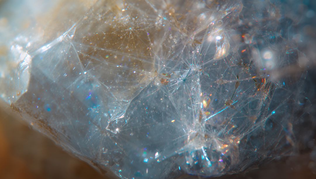 Macro translucent mineral specimen revealing fibrous inclusions and iridescent shimmer