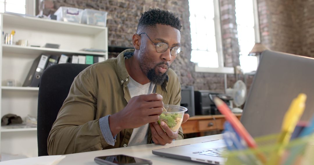 Focused Young Professional Eating Healthy Salad at Office Desk - Free Images, Stock Photos and Pictures on Pikwizard.com