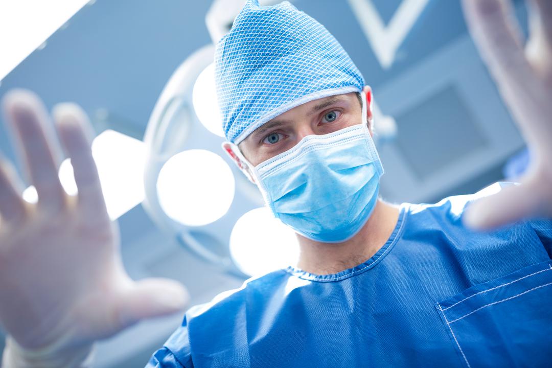 Surgeon in Operating Room Wearing Surgical Mask and Scrubs - Free Images, Stock Photos and Pictures on Pikwizard.com