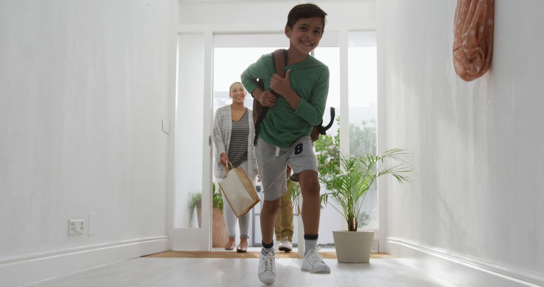 Cheerful Boy Running Indoors with School Bag