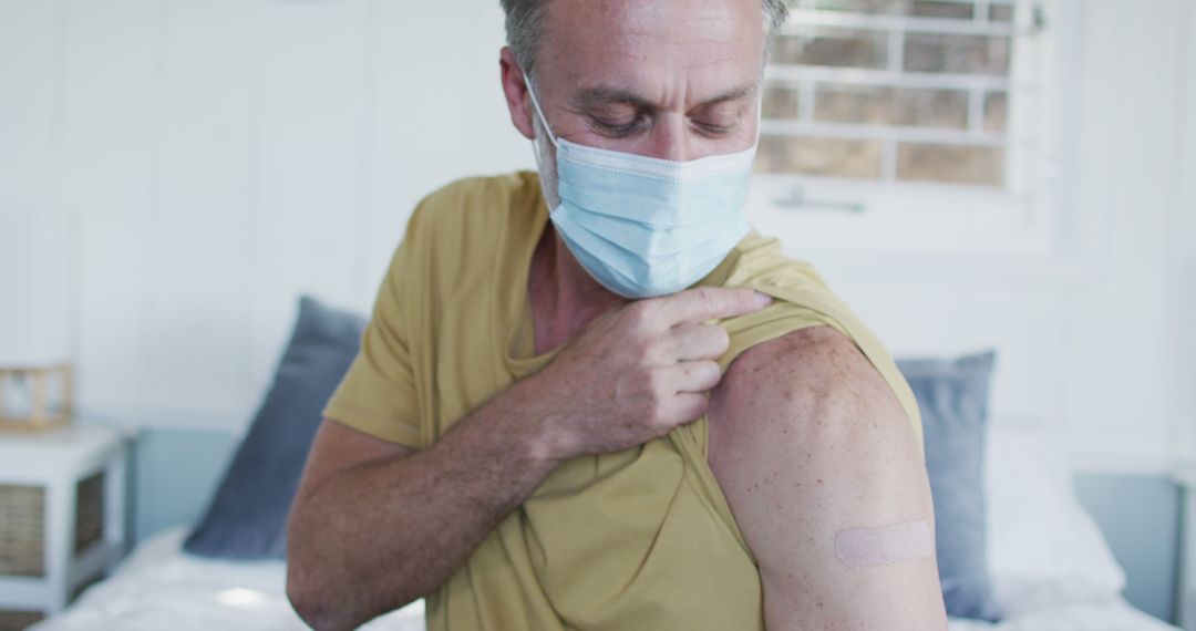 Man Showing Vaccination Bandage at Home - Free Images, Stock Photos and Pictures on Pikwizard.com