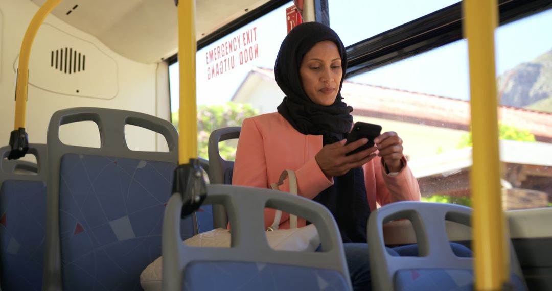 Hijabi Woman Seated on Public Bus Using Smartphone - Free Images, Stock Photos and Pictures on Pikwizard.com