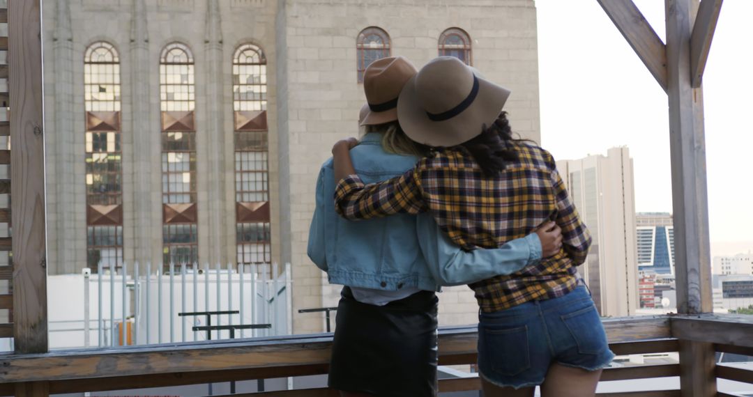 Diverse Female Friends Embracing on City Rooftop