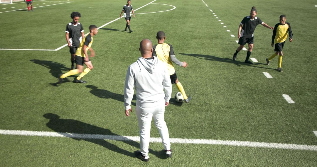 Coach Leading Soccer Team in Dynamic Practice Drills on Field