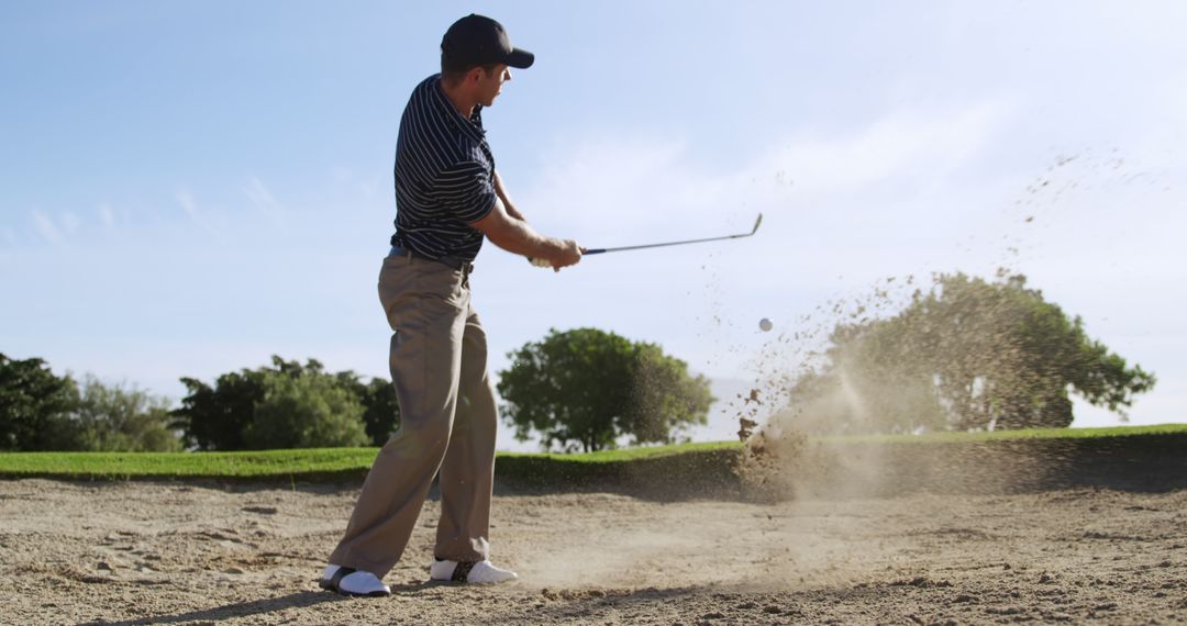 Golfer Executing Dramatic Bunker Shot on Golf Course