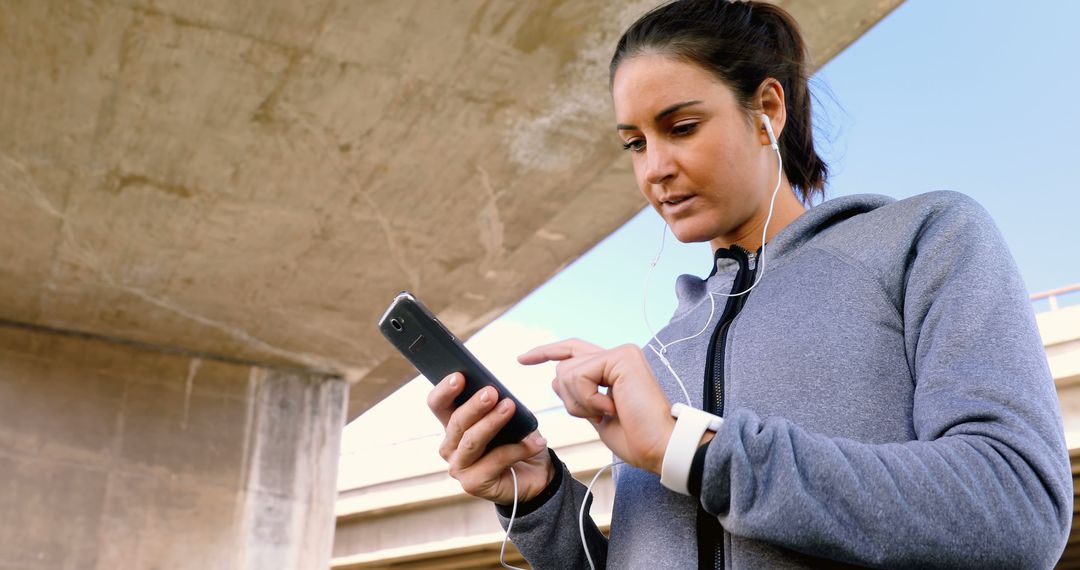 Focused woman in sportswear using smartphone during workout - Free Images, Stock Photos and Pictures on Pikwizard.com