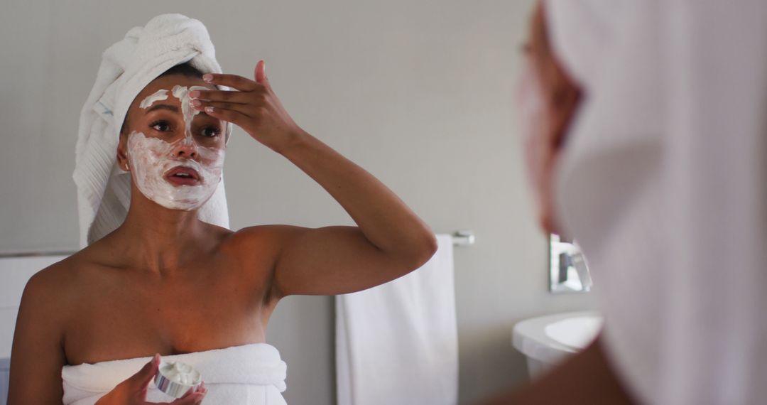 Woman Applying Face Mask in Bathroom Mirror Reflection - Free Images, Stock Photos and Pictures on Pikwizard.com