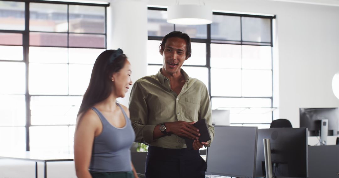 Happy Colleagues Discussing Work in Open Office Setting