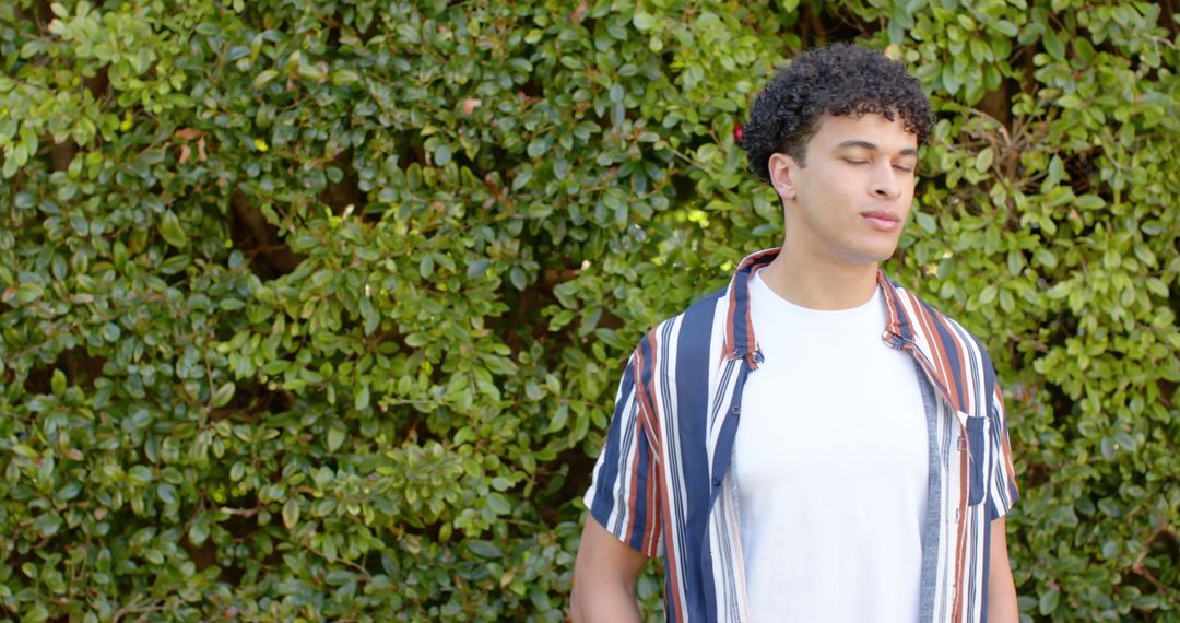 Young Man Standing Still with Eyes Closed Outdoors - Free Images, Stock Photos and Pictures on Pikwizard.com