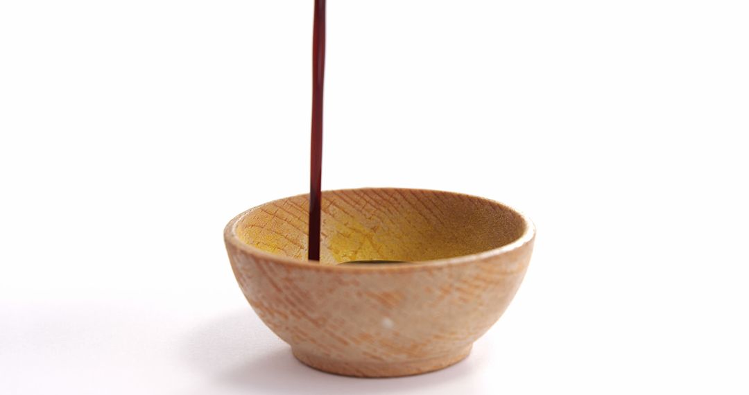 Pouring Soy Sauce into Rustic Wooden Bowl on White Background - Free Images, Stock Photos and Pictures on Pikwizard.com