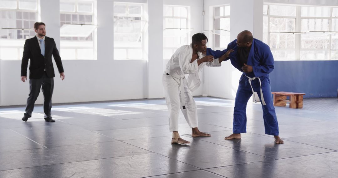 Martial Arts Students Practicing Grappling Techniques on Mat