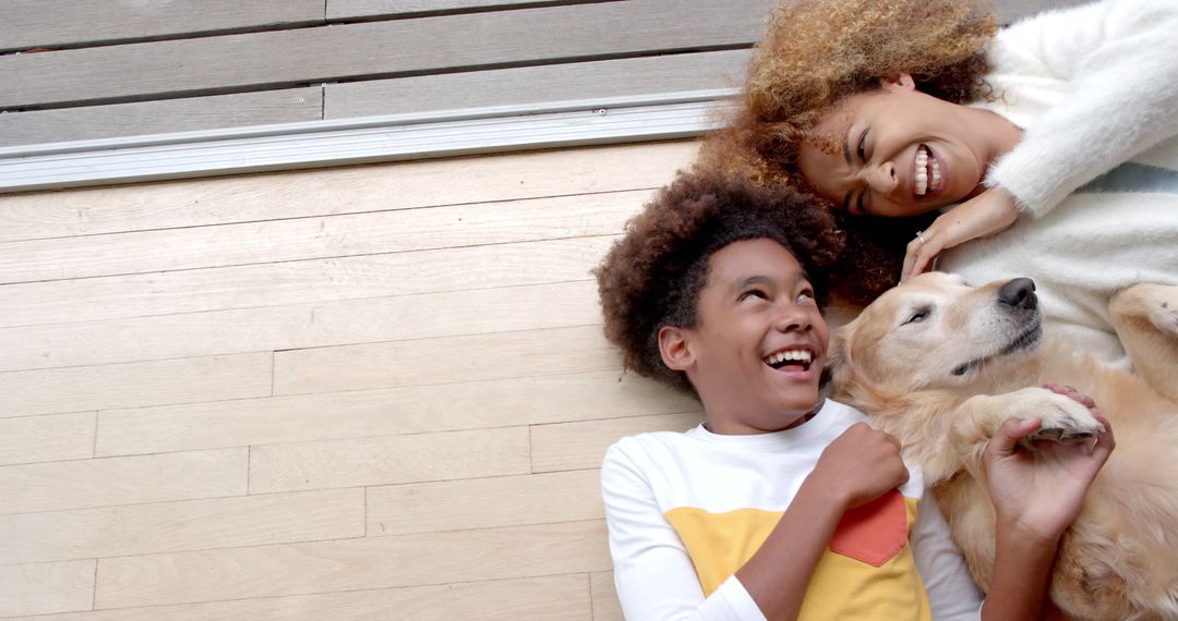 Joyful Mother and Son with Golden Retriever Relaxing on Floor