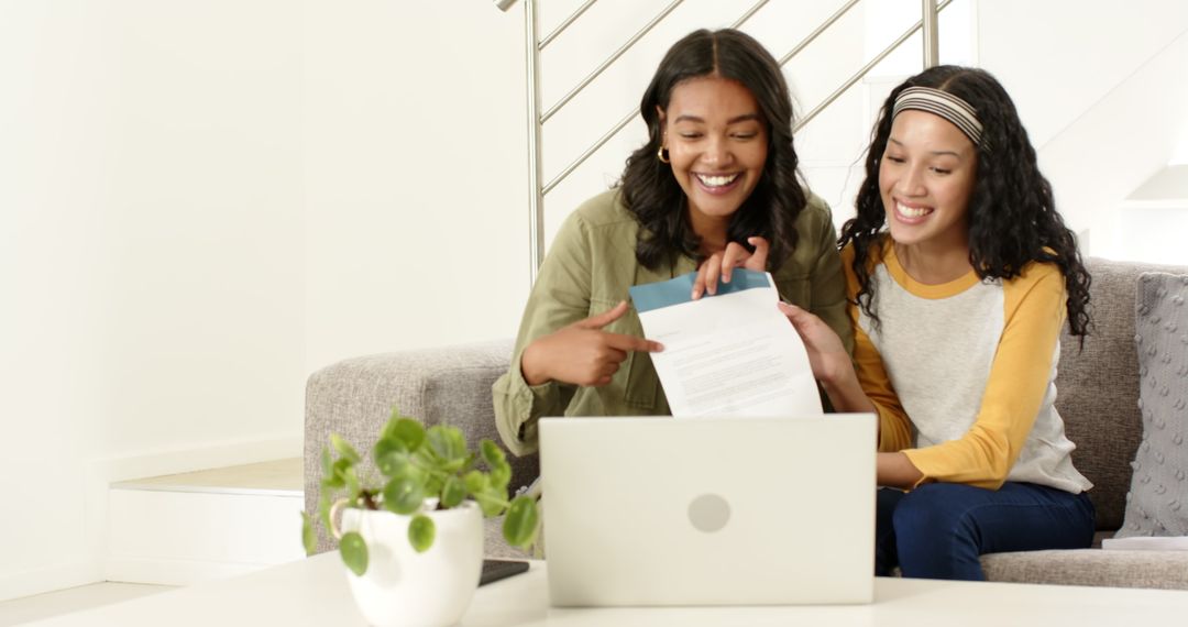 Two Women Smiling While Video Chatting on Laptop in Comfortable Home