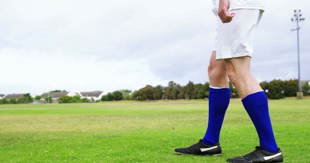 Soccer Player Standing on Outdoor Green Field in Game Attire - Free Images, Stock Photos and Pictures on Pikwizard.com