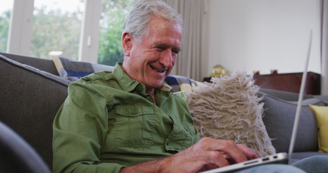 Senior Man Smiling While Using Laptop in Cozy Living Room - Free Images, Stock Photos and Pictures on Pikwizard.com