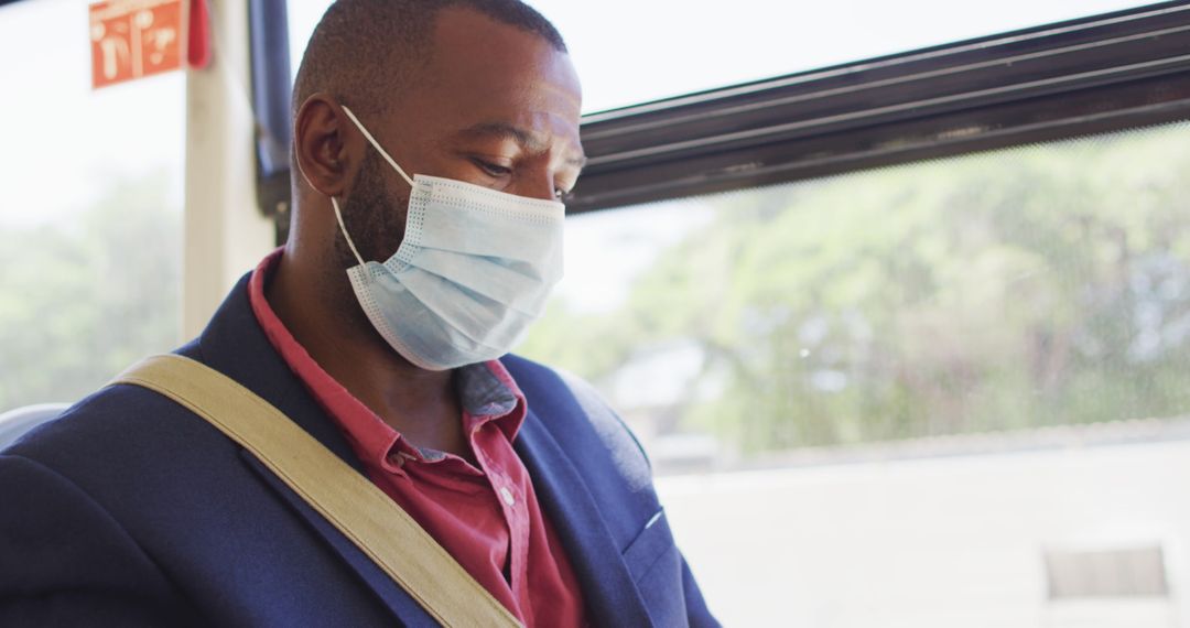 Man Wearing Face Mask Using Smartphone on Bus for Safe Travel