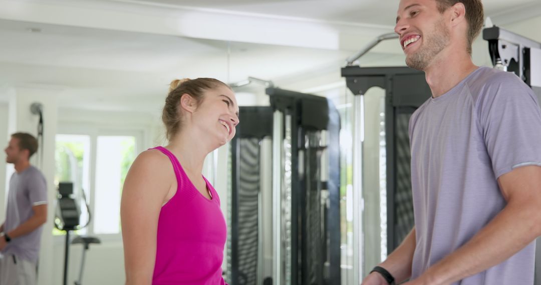 Couple Smiling and Exercising Together at the Gym