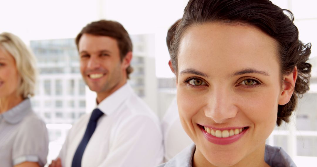 Smiling Professional Woman in Office with Colleagues - Free Images, Stock Photos and Pictures on Pikwizard.com