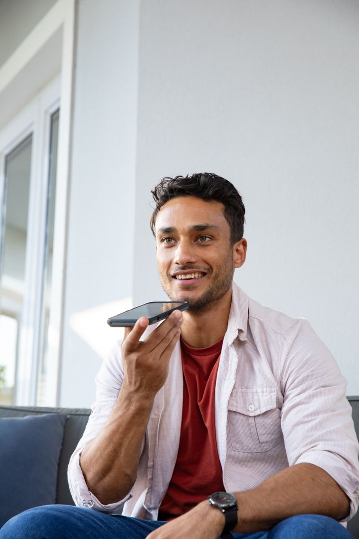 Man Communicating via Smartphone Voice Commands in Cozy Home Setting