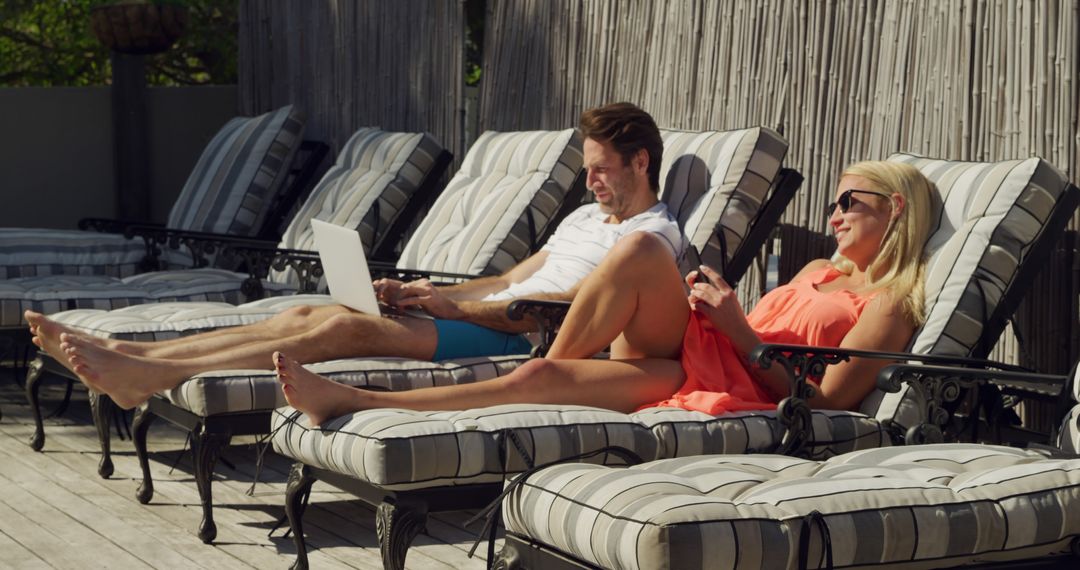 Couple Relaxing on Deckchairs with Devices by Poolside - Free Images, Stock Photos and Pictures on Pikwizard.com