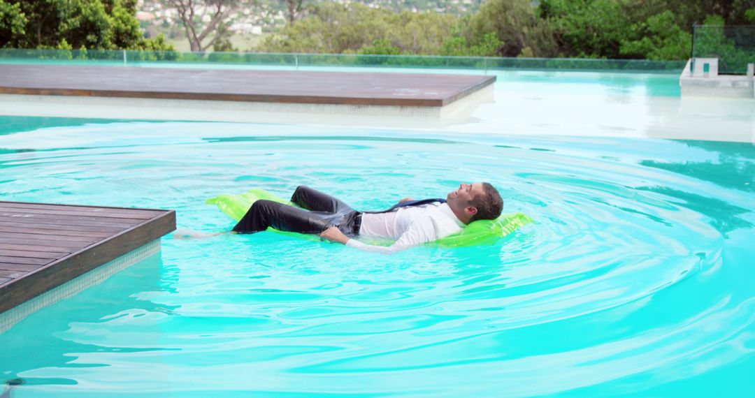 Businessman Relaxing in Pool with Green Inflatable Mat - Free Images, Stock Photos and Pictures on Pikwizard.com