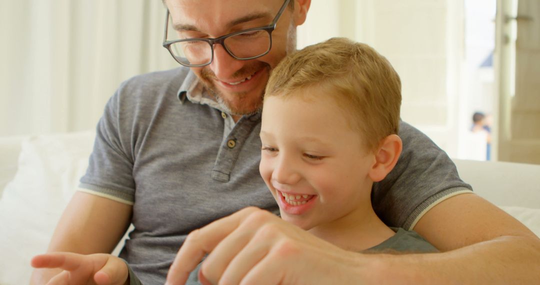 Father and Son Smiling While Using Digital Tablet - Free Images, Stock Photos and Pictures on Pikwizard.com