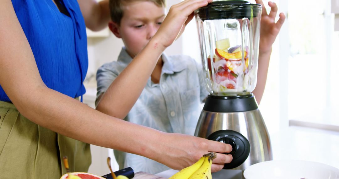 Mother and Son Making Fruit Smoothie Together in Kitchen - Free Images, Stock Photos and Pictures on Pikwizard.com