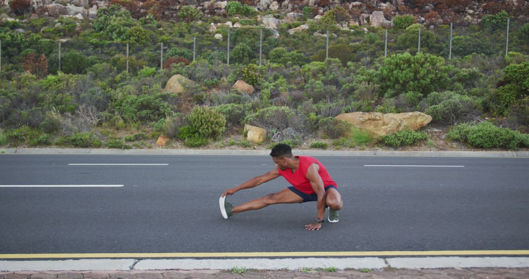 Fit Man Stretching Next to Scenic Roadway Vegetation