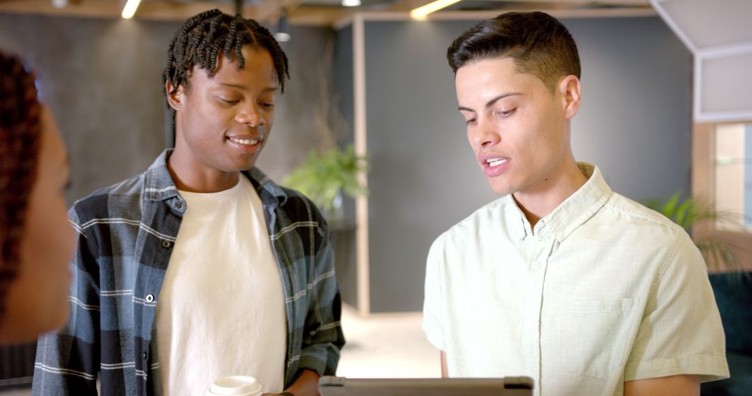 Professional Colleagues Discussing Project on Tablet in Modern Workplace