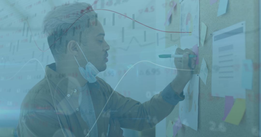 Young Professional Analyzing Financial Data with Face Mask