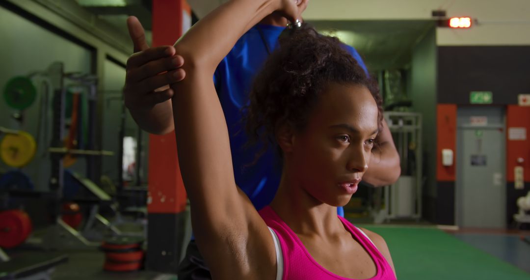 Personal Trainer Assisting Woman During Arm Stretch in Gym - Free Images, Stock Photos and Pictures on Pikwizard.com