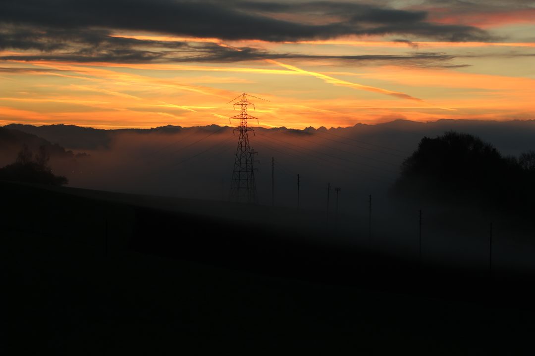 Electricity Pylon Silhouette at Sunset with Misty Horizon - Free Images, Stock Photos and Pictures on Pikwizard.com