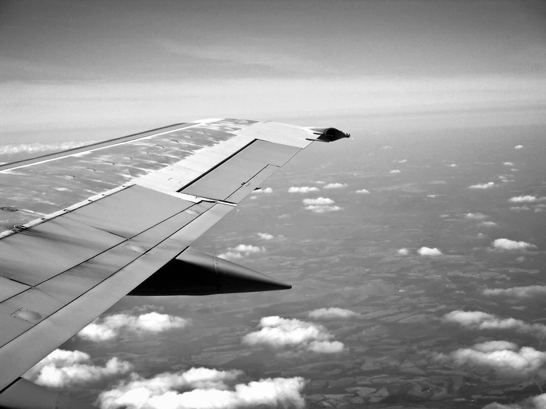 Black and White View of Airplane Wing Flying Above Clouds - Free Images, Stock Photos and Pictures on Pikwizard.com