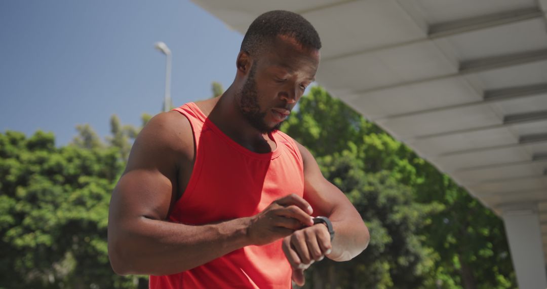 Male Athlete Checking Smartwatch During Outdoor Workout - Free Images, Stock Photos and Pictures on Pikwizard.com