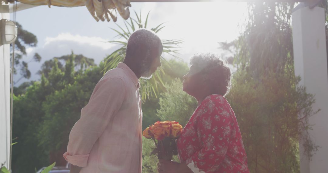 Elderly Couple Sharing Tender Moment Outdoors with Flowers - Free Images, Stock Photos and Pictures on Pikwizard.com