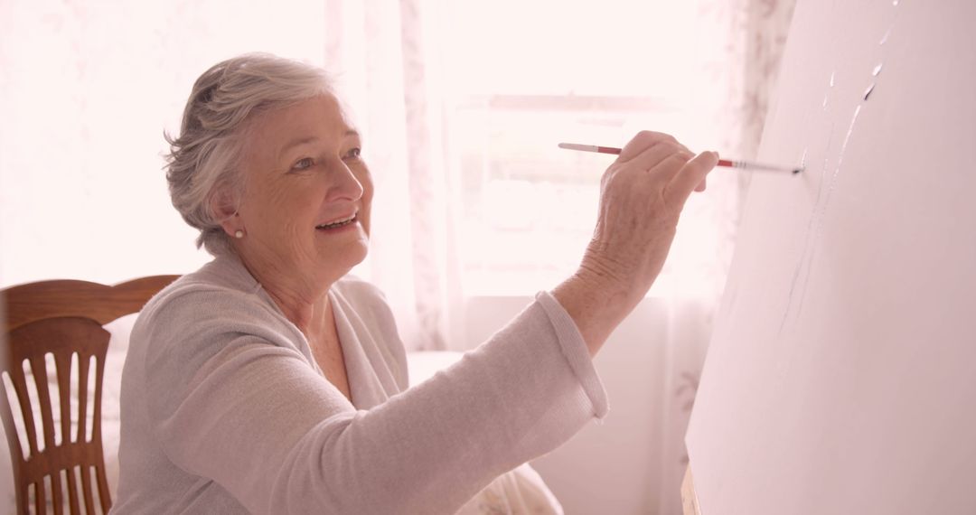 Senior Woman Painting on Canvas in Bright Room - Free Images, Stock Photos and Pictures on Pikwizard.com