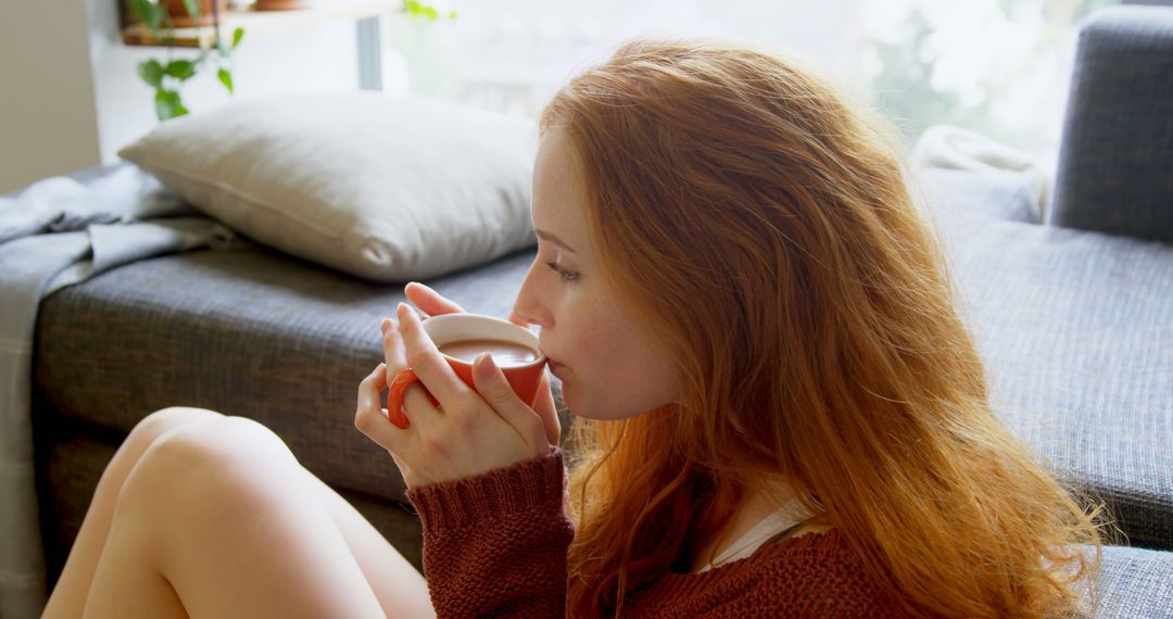 Woman with Red Hair Drinking Coffee and Relaxing at Home - Free Images, Stock Photos and Pictures on Pikwizard.com