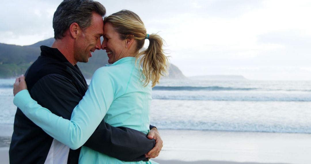 Middle-aged couple embracing on beach during sunset - Free Images, Stock Photos and Pictures on Pikwizard.com