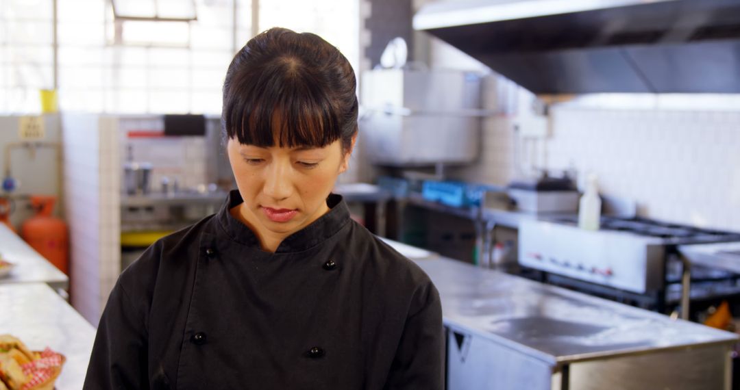 Asian Female Chef Concentrating in Professional Kitchen - Free Images, Stock Photos and Pictures on Pikwizard.com